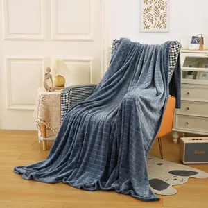 Gemütliche blaue Flanelldecke mit Waffelmuster auf orangefarbenem Sessel.