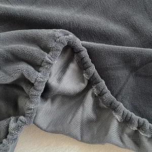 Detalle de sábana bajera de franela gris que muestra textura suave y dobladillo elástico.