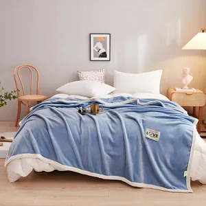 Cozy blue milk velvet flannel blanket with decorative patch in bedroom lifestyle setting