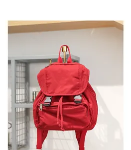 Mochila vintage de lona roja con bolsillo frontal y cierre de hebilla en la solapa
