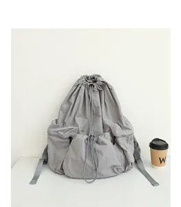 Primer plano de una mochila gris de nailon con cordón y textura arrugada moderna