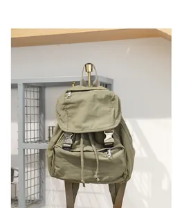 Detalle de mochila de lona verde oliva con acabado lavado y hebilla vintage