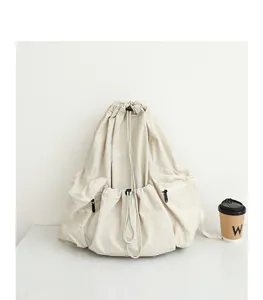 Vista detallada de una mochila beige de nailon plisado con cordón ajustable