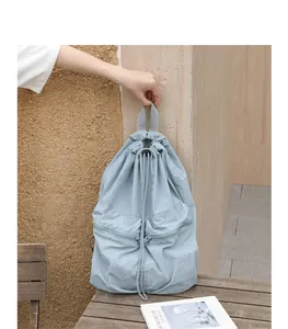Detail eines hellblauen Nylon-Rucksacks mit Kordelzug in lässiger Außenumgebung