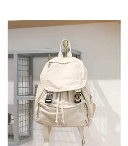 Vista detallada de una mochila de lona beige con acabado lavado vintage y hebillas