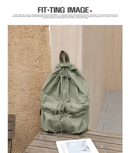 Detailansicht eines salbeigrünen japanischen Nylon-Rucksacks mit Kordelzug auf einem Tisch