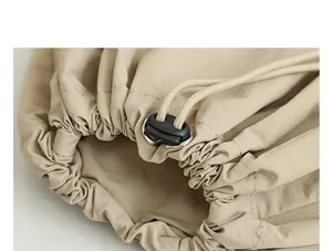 Detalle de primer plano del cierre de cordón en una elegante mochila de nailon beige.
