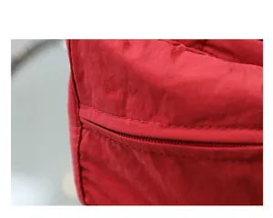 Primer plano de mochila de lona lavada roja con detalle de cremallera y costuras