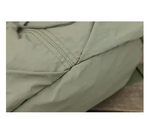 Detailansicht eines langlebigen grünen Nylon-Rucksacks mit feinen, verstärkten Nähten.