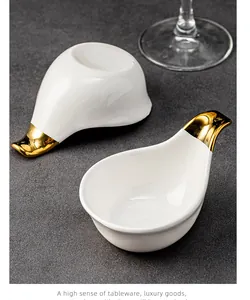 Elegant bird-shaped ceramic dipping sauce dish with high-quality gold-plated handle detail.