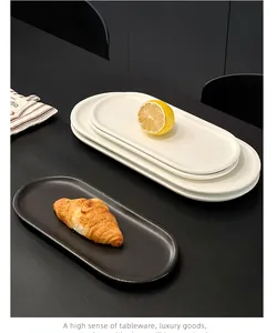 Λεπτομερής άποψη lifestyle από μίνιμαλ οβάλ κεραμικά πιάτα σε μαύρο και λευκό χρώμα