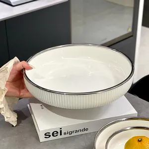 Plat de service élégant en céramique blanche avec rayures verticales et bord argenté