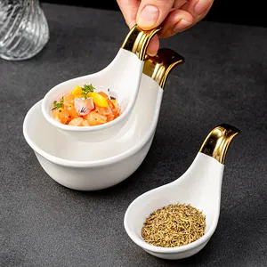 White ceramic appetizer spoons with gold handles for caviar and sauces display