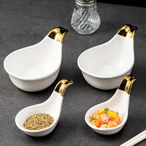 Elegant white ceramic dipping bowls with gold bird handles for appetizers and sauces