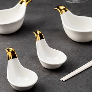 Elegant bird-shaped white ceramic sauce dishes with gold tips for seasoning and snacks.
