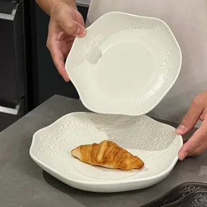 Minimalistischer weißer Pastateller aus Keramik mit Hammerschlag-Rand und Wellenkante