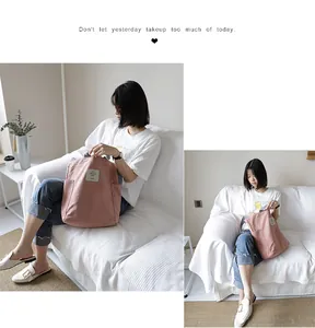 Lifestyle view of a pink casual canvas handbag shown with a model on a white sofa.