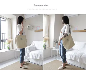 Lifestyle view of model carrying a stylish beige canvas shoulder bag in a room
