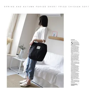 Large capacity black canvas tote bag presented in a stylish lifestyle indoor setting