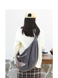 Modelo luciendo un bolso bandolera hobo grande gris carbón con textura de gofre