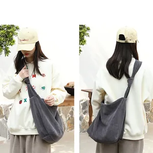 Front and back view of a grey corduroy crossbody bag with a knotted strap detail