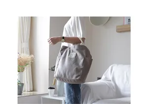 Casual gray canvas shoulder bag carried by a woman in a bright minimalist living room