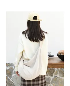 Detalle de la bolsa de pana crema de gran capacidad llevada por una modelo en entorno casual