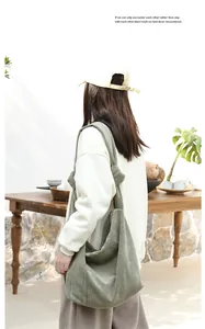 Back view of a model wearing a green corduroy crossbody bag with a stylish knotted strap