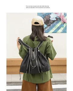 Vista trasera de una mochila minimalista de lona negra con correas de contraste