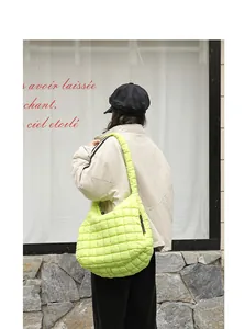 Detail view of a vibrant lime green quilted nylon bag in a casual street style setting.