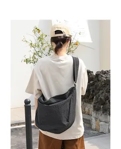 Vista trasera de un bolso hobo de lona a cuadros de estilo japonés usado por modelo