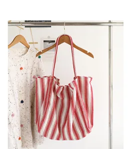 Borsa tote in tela a righe rosse e bianche in stile giapponese appesa a un supporto