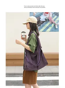 Modelo asiática con un gran bolso tote de lona a cuadros morados en un estilo casual.