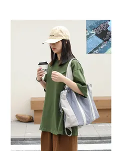 Elegante bolso tote de lona con cordón y bloques de colores usado por una modelo en la calle