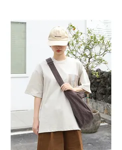 Mujer joven con un bolso bandolera japonés vintage de lona con estampado de cuadros