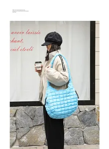 Close-up detail of a light blue quilted nylon crescent shoulder bag worn by a model