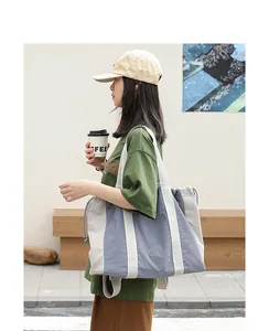 Modelo luciendo un bolso tote casual de nailon en colores contraste y cierre de cordón.