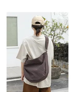 Vista posterior de una modelo con un bolso bandolera de lona a cuadros marrón