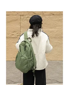 Vista trasera de una mochila de nailon verde de estilo japonés con cordón y textura plisada