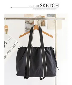 Versátil bolso tote de nailon negro con cordón y correas en contraste en un perchero