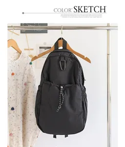 Vista detallada de una mochila informal de nailon negro colgada en un perchero de ropa