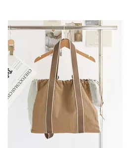 Primer plano de un bolso tote de nailon marrón y gris claro con cordón ajustable