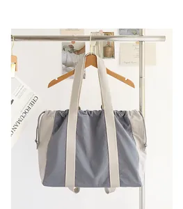 Bolso tote de lona y nailon con cordón y diseño color-block colgado en un soporte