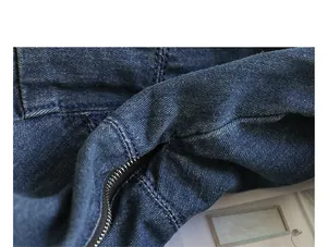Close-up macro view showing the durable blue denim fabric texture and zipper of the bag.