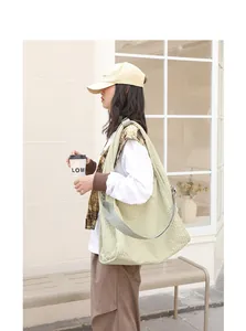 Bolso tote grande de lona con textura de cuadros verde matcha llevado por una modelo
