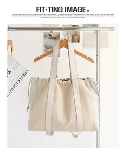 Bolso tote minimalista de nailon con cordón y paneles de contraste en un perchero.