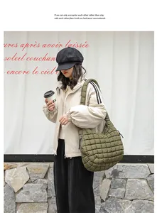Detail view of a stylish army green quilted nylon hobo shoulder bag worn by a model