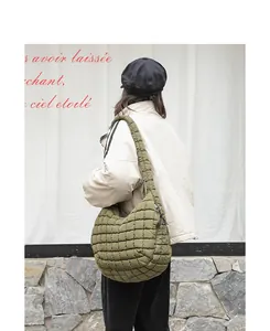 Close-up detail shot of the stylish olive green quilted nylon shoulder bag on a model