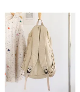 Vista trasera detallada de una mochila de nailon beige minimalista de estilo japonés casual.