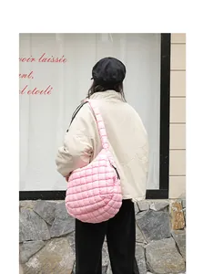 Model wearing a pink quilted puffer shoulder bag in a casual street style lifestyle setting.